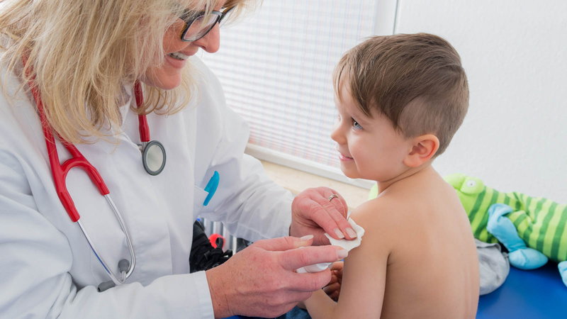 Doctor wiping child for vaccine