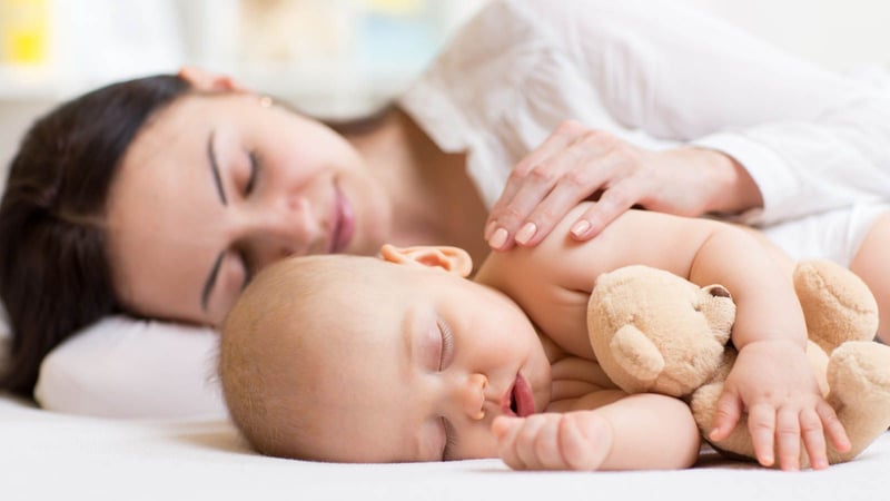 Sleeping mother holding sleeping baby holding stuffed animal