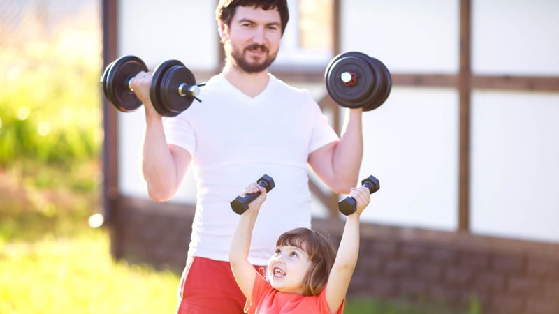 dad and daughter lifting dumbbells