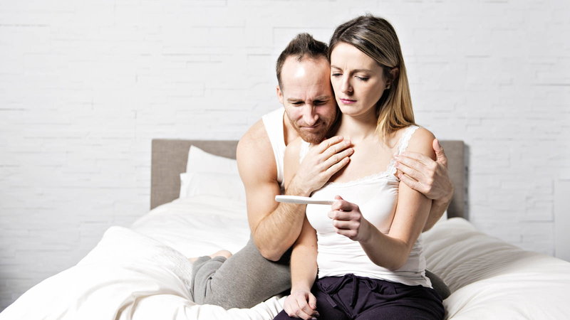 disappointed couple looking at pregnancy test