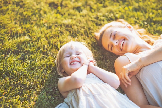 mom and daughter laughing on the grass