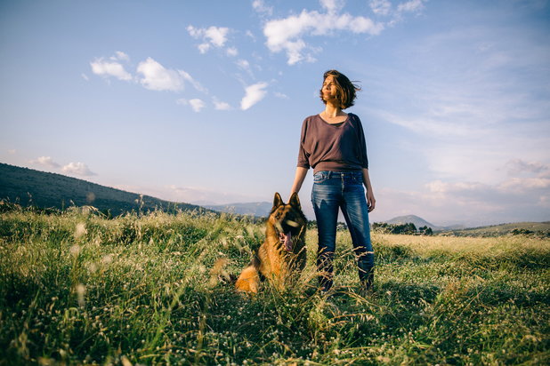 woman standing next to dog
