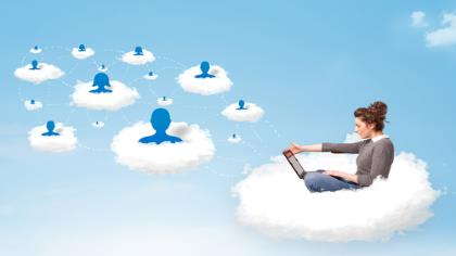 A woman sits on a cloud with a laptop. 