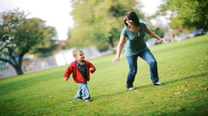 A mom and her son playing in the park.