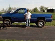 This is a picture of me standing in front of dads dodge with a 12 valve cummins in it.We bale hay off of the field in the background.