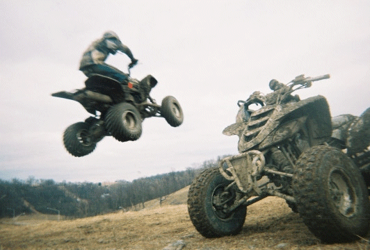 My friend Joe in the air on his Z400 jumping off a huge hillclimb. That's my friend Bobs Raptor next to it.