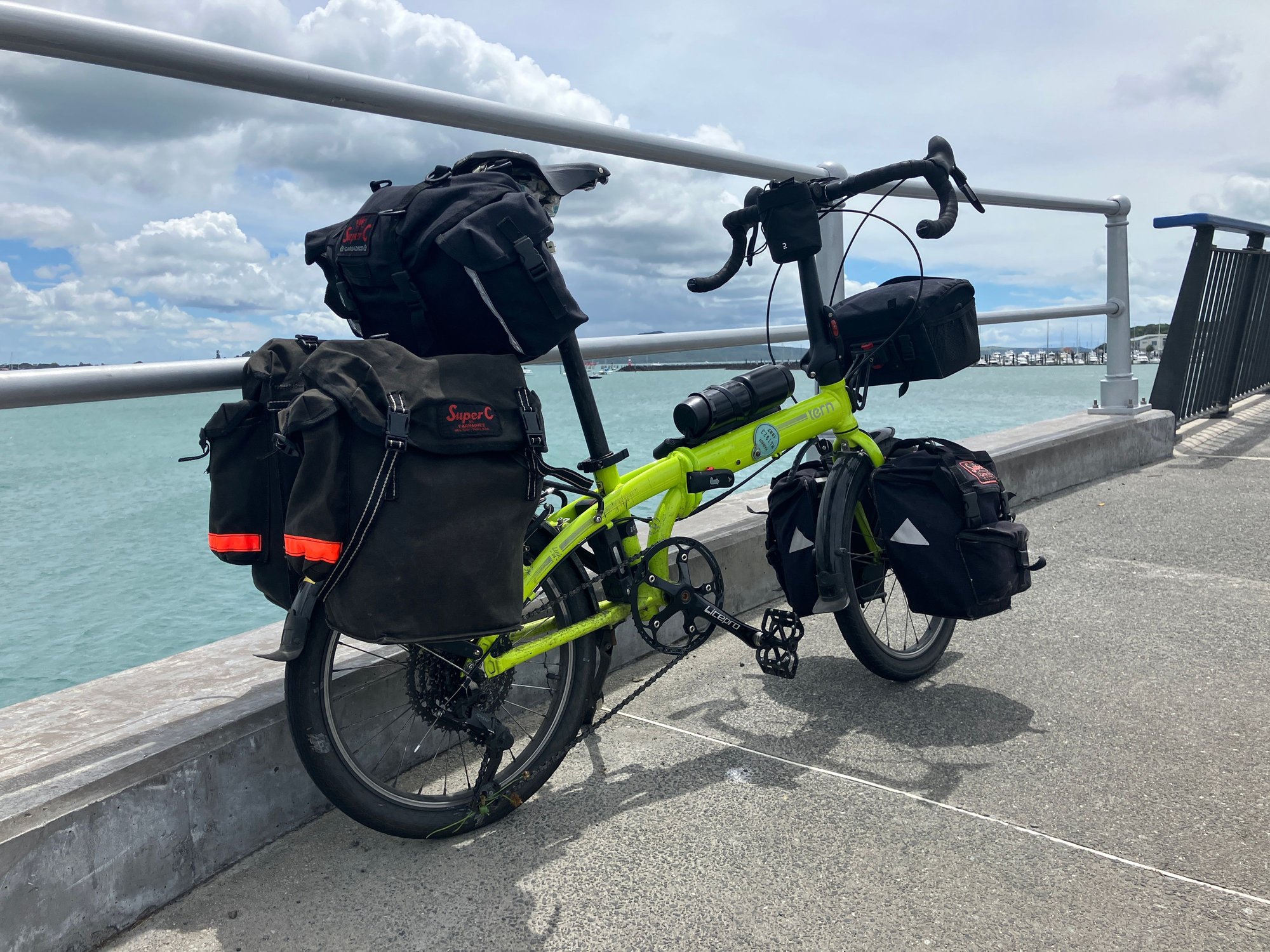 Another vote for the Carradice Super C front panniers with a Tern Spartan rack, with the proviso that it’s a bit of a faff getting the lower clips on the panniers connecting up with the bottom of the rack. That said they’re small enough and sturdy enough not to need them held firmly in place there.