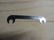 Offset brake wrench from Park  inexpensive and the part is OBW-1.   You can also remove some of the material from the wrench, so that it just fits into the post flats from the bottom with the tire still inflated.