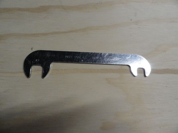 Offset brake wrench from Park  inexpensive and the part is OBW-1.   You can also remove some of the material from the wrench, so that it just fits into the post flats from the bottom with the tire still inflated.