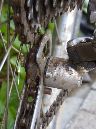 Derailer with chain on #1 sprocket.
White arrow: Jockey pulley nut clears spokes easily.
