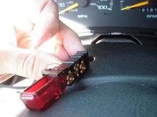 Hazard switch showing the Tab.  The little triangular tab in front of my thumbnail is the only thing holding the Hazard assembly into the steering column.  These switches are about 15 dollars at the dealership.