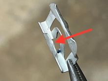 The red arrow shows the tab that doesn't hold the clip tightly.