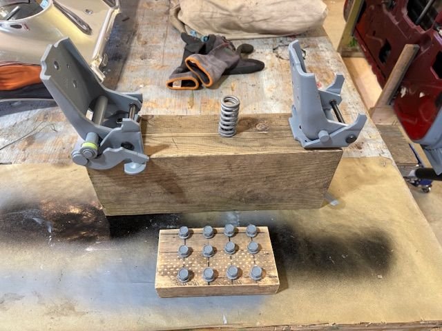 Hinge bolts, hinges, and detent spring jigged up for painting.