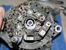 the brush assembly is held down by three screws...be sure to use a GOOD condition #2 phillips for removal with good down pressure..you don't want to strip them out! Then the two round head (#2) screws hold down the terminal block..I snapped on of the field terminals when removing the nut..this was a result of rust and uneven pressure being applied trying to get the nut to spin loose...boooo