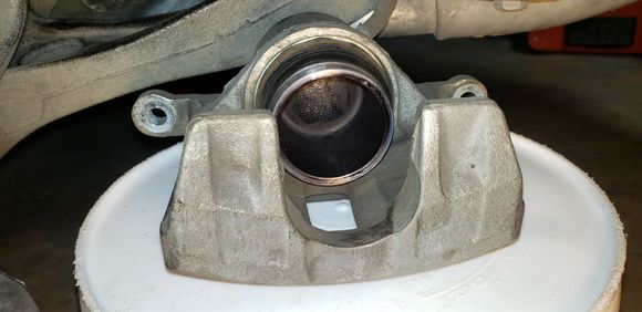 I did this a month ago before I knew better: sanded off the rust as much as I could, cleaned with IPA, sprayed Mar-hyde 3509 one-step rust converter, heat resistant to 200°F (https://www.3m.com/3M/en_LB/p/d/v000207848/). As the manufacturer claimed, remaining rust turned to black as part of the latex primer sealer. Not sure how long it's going to last as is. I still have an option to coat it with caliper paint. Should I?