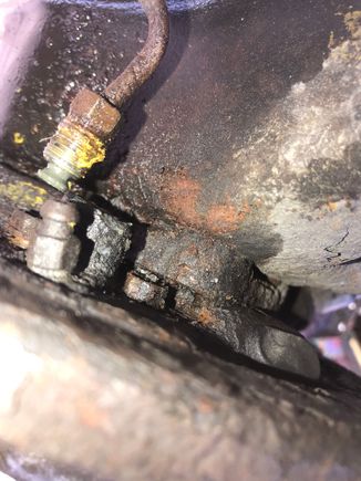 It’s the bolt on the right of the hanging brake line