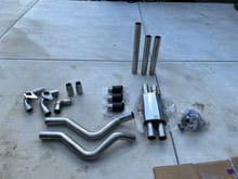 items laid out.  showing missing parts.  got only 3 tips,  missing one straight pipe,  missing 90 degree exhaust tip connecting pipe.