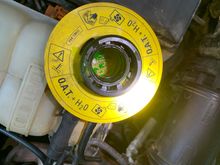 Coolant expansion tank with cap off - shows some metallic crud floating on surface 