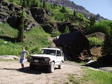 SanJuanPicsJuly22011.  Old mine building leaning precariously in the old Sneffels town area up Yankee Boy Basin above Ouray.  The wife is gripping the Rover so it does not turn turtle and roll down the slope.