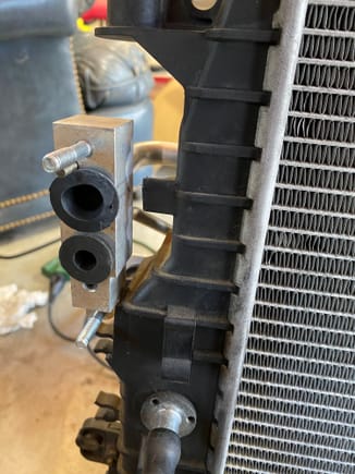 I also cut the condenser port mounting tabs off.  The aftermarket condenser coil didn’t fit perfectly to the tabs.  I think that maybe this will also make a future radiator job easier.