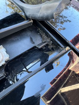 When you are done cleaning the drain channels - also look under the front corners - under the rubber weatherstrip - it just pulls up. All sorts of gook under there.  I believe this is important as it is likely where the secondary drain holes up front are -- somewhere under there. 