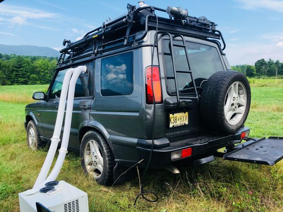 The back right shows the custom base made for the trip. Connected to a Swing Away hitch mount carrier.