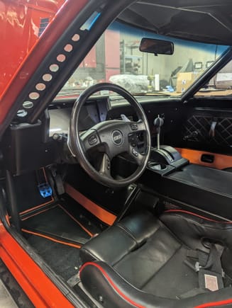 The interior was my job.  Mark let me do what I wanted.  From carpet to headliner.  The center console is made of mdf.  The Holley Dash has a 3D printed surround with a black vinyl wrap and carbon fiber trim.  The Shifter knob is a 3D printed test piece that's now permanent.  We used the TrailBlaze steering wheel.  The buttons on the wheel control a custom heater/defroster.  The wiper controls work too.  A custom BCM was made using an Arduino to control the wipers and the heater.  