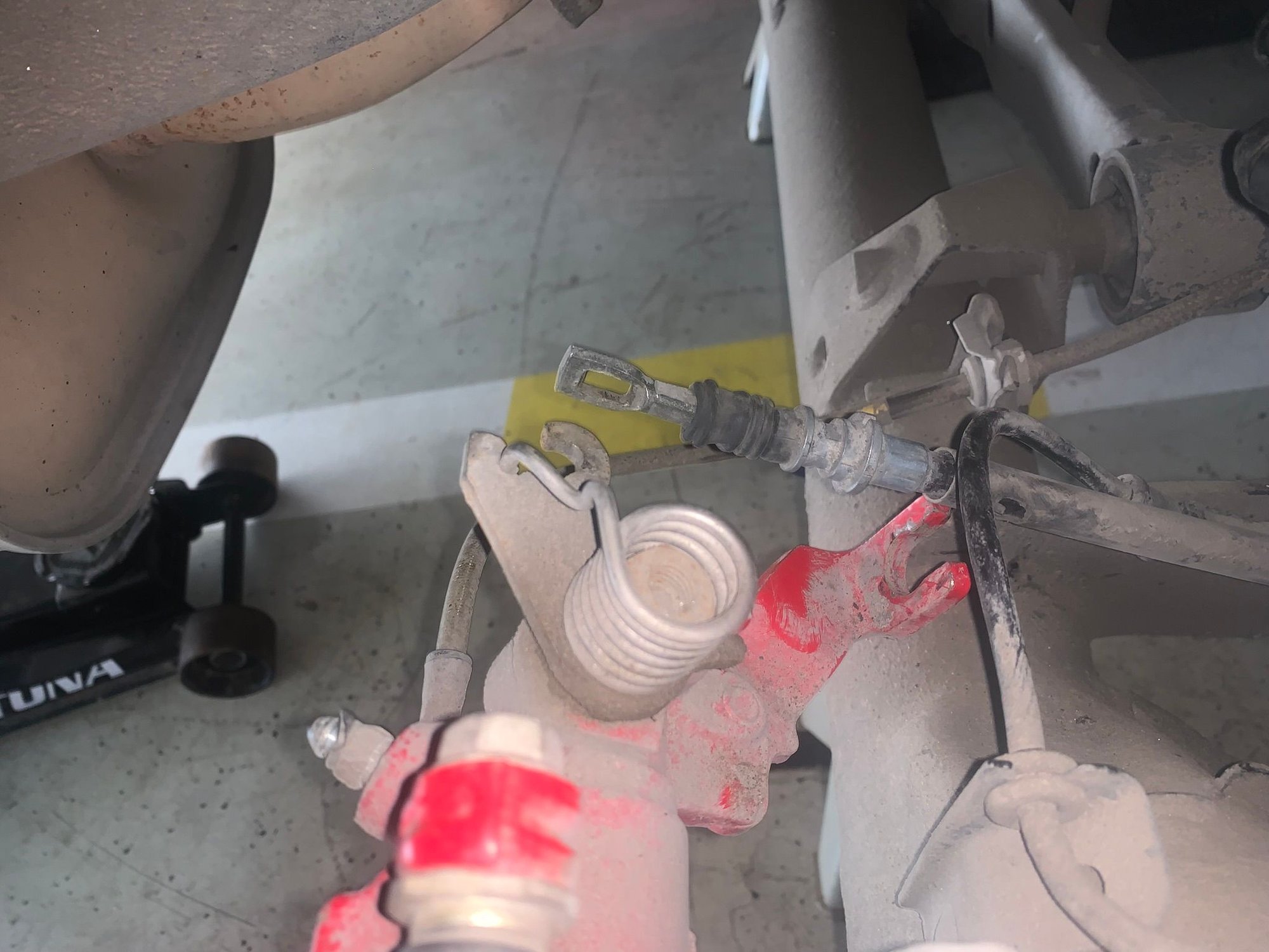 Passenger side, unhooked from caliper lever, with collapsed boot