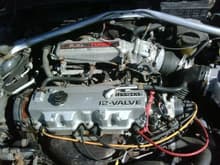 this is the 1990 Mazda mx-6's power plant. it was a 4 cylinder, 2.2L, 12 valve, turbo charge engine. The upper strut bar is from a Toyota Celica