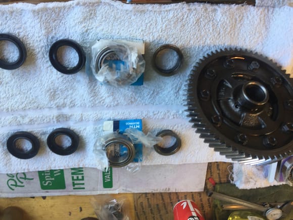 Diff assy with old bearings and seal and new ones next to it. The bearing for the front and back is identical. The driver side seal is different than the passenger side one. The diameter is the same but the lip construction is different.