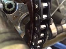 Up-close shot of the wear depth of the chain onto the guide rails of the chain tensioner.