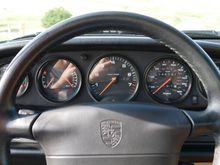 Leather-wrapped steering wheel frames the central tachometer with current odometer reading 47K miles.