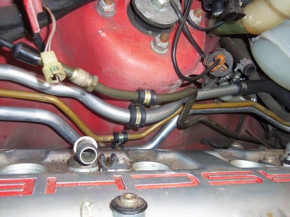 Shot of the fuel supply line, metal water tube, AC lines, and the new P-clamps holding them in place.