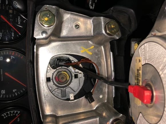 This red plug pulls directly off the back of the airbag. No clips holding it.  It’s just a snug fit.  Also the four bolts on the corner are where the o-rings go to fix the infamous problem with the horn blowing randomly.