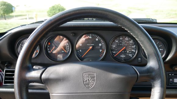 Leather-wrapped steering wheel frames the central tachometer with current odometer reading 47K miles.