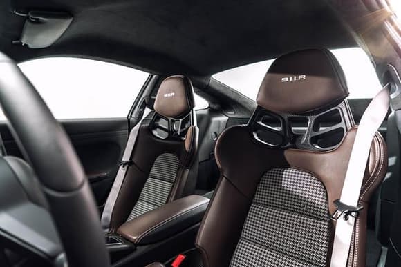 911 R seats in brown (forget the name of the brown) leather with black/silver houndstooth and standard platinum silver stitching.