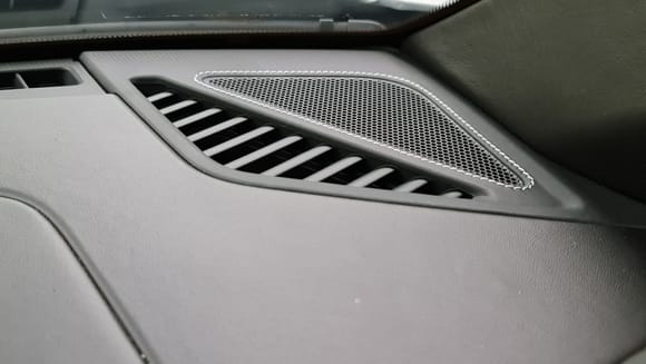 Dash speaker grilles wrapped in leather with deviated stitching. 