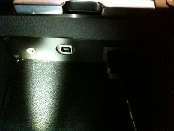 Escort 9500c1 software update unit installed in center arm console next to iPod interface and USB port.
