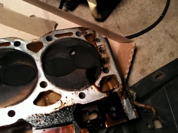 This is the cylinder side of the head, you can see where the oil is caked on. A small strip of it was a fresh dripping, but the rest has been there for a while obviously.  What causes that?