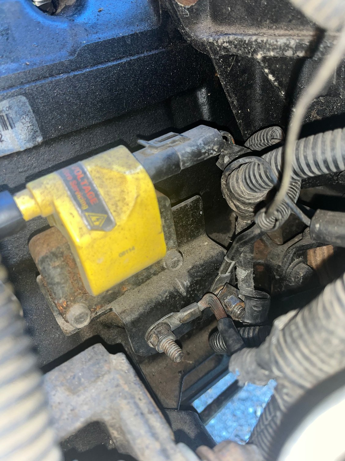 grounds underneath the ignition coil