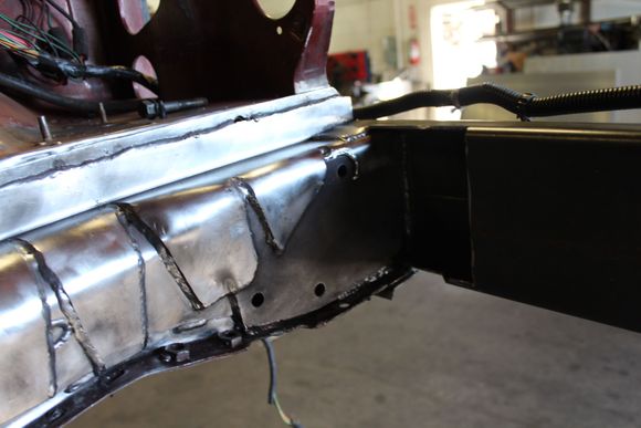 This shows how behind the steering box I have multiple layers, first the flat plate(11 gauge material) extends to the new "front bracing/rectangular tubing".  then I plated over that by welding in a 1/4 plate for the steering box to bolt through (both drive and passenger side were plated, the  1/8 material wraps over the top of the steering box plating to tie it all together. 
In the shadowed area you can see the opening in the rectangular tubing so the front of the steering box would clear.
