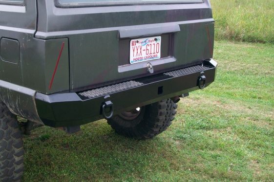 Aggressor Series Rear XJ Bumper with hitch, D-rings, full 3/8" thick Unibody tie-in brackets as well as factory style.
Wraps tightly with body lines and has contoured tail light fillers with optional step pads.  Mounts with 16 grade 8 bolts.