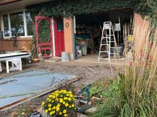 Old damaged ugly door lying on the driveway and the opening frame cleaned up.
