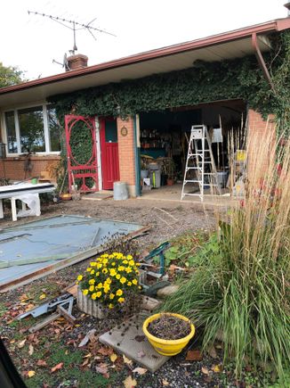 Old damaged ugly door lying on the driveway and the opening frame cleaned up.
