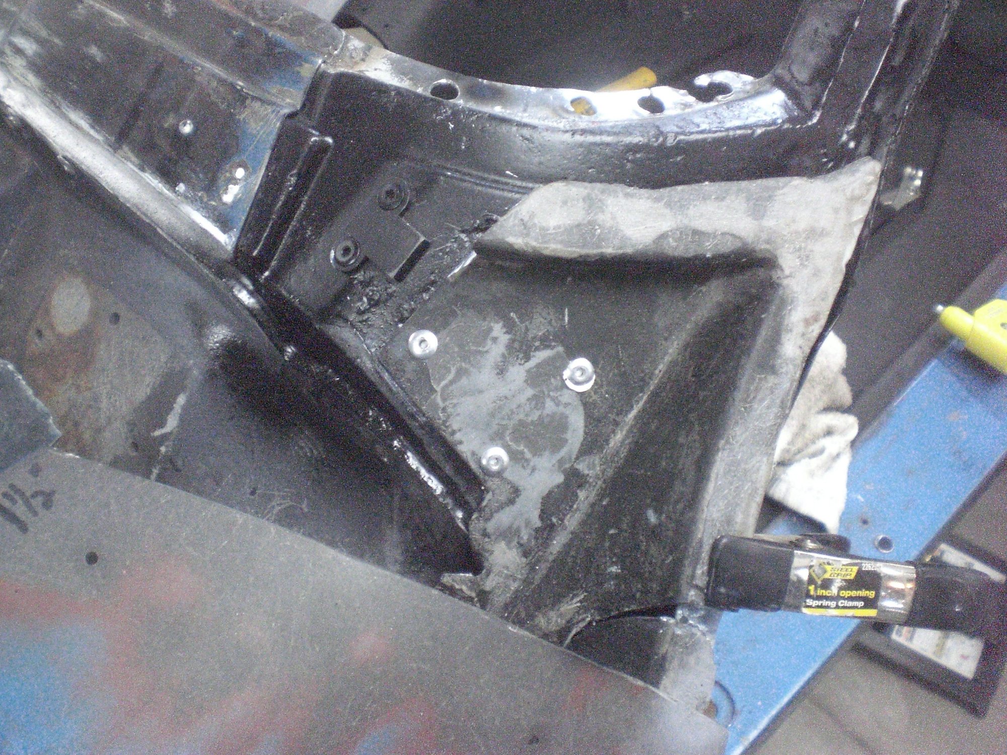 Mounting structure was then riveted onto the outer corner.  A bonding tab (under the spring clamp) was used to secure the cut pieces bonding edge to that of the fixed support structure.