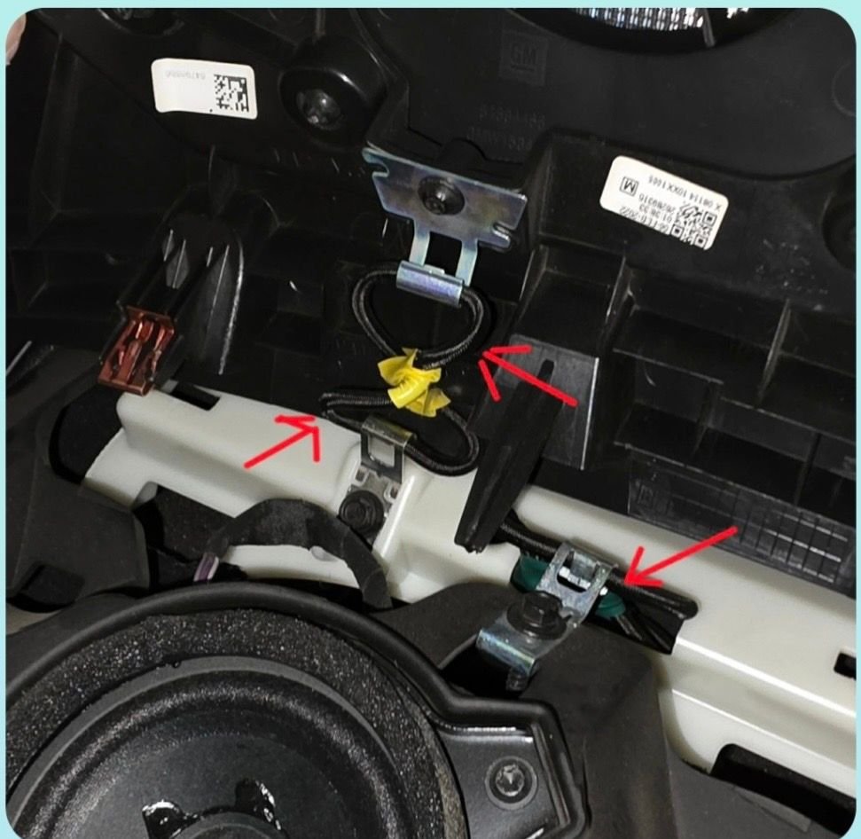 Bungee like cord attaches speaker cover to bezel.