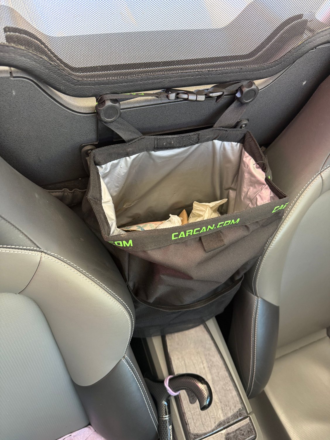 Open insulated storage or trash bag, two mesh cup holders on sides, one pocket on front.