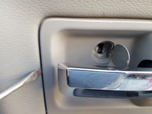 pry the door handle trim piece to remove it from the door panel.