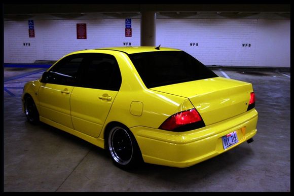 Guys this is what I want my Lancer to look like, at least from this angle. I'm sure this one has and aftermarket front bumber from this angle I'm loving the view. No spoiler, no loud exhaust, and remove the lancer es words from the trunk. Just keep it simple neat and clean. Aftermarket rims? Of course a must. But that's it for the outside. Everything else keep it looking stock. Even the lights keep it stock. I'll keep my car black and tint windows :) oh and lowering springs? Yes lol.