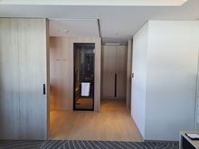 Bathroom from the bedroom. Bathroom sliding doors fully open. Toilet to the right . Cupboard at the far end with entrance door to the right out of sight